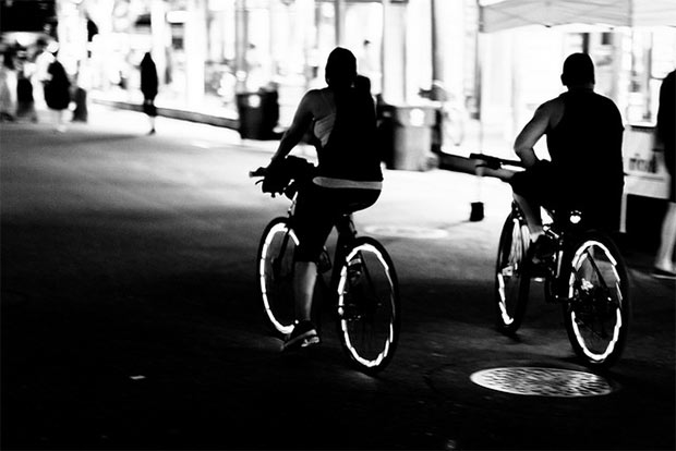 des cyclistes roulant dans une rue sombre