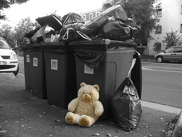 Un ourson devant des poubelles