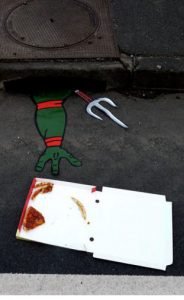 Une tortue ninja attrapant une boite à pizza.