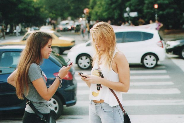 2 filles sur leur téléphone dans la rue