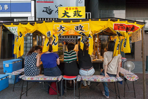 Des passants assis à un stand dans la rue 