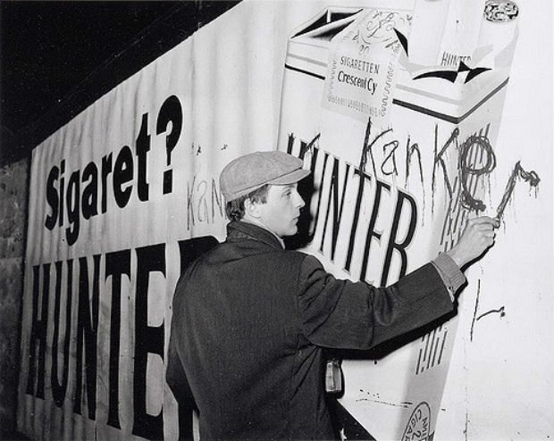 Robert Jasper Grootveld tague une publicité sur le tabac à Amsterdam, en décembre 1961