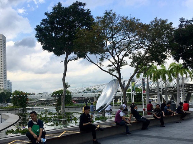 photo où des singapouriens sont assis au bord de la mer