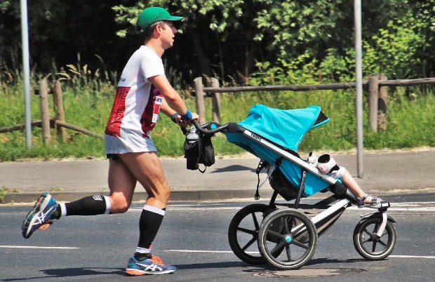 Joggeur courant avec une poussette en ville. Source : ©️Pixabay