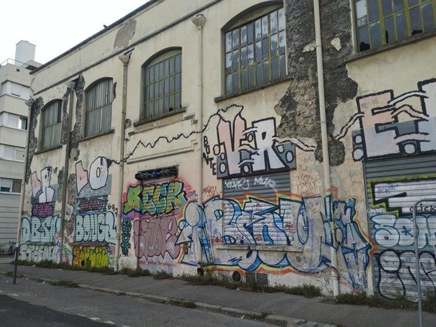 Un bâtiment couvert de graffitis dans le quartier de Jean-Macé, Lyon. Crédit photo : CT.